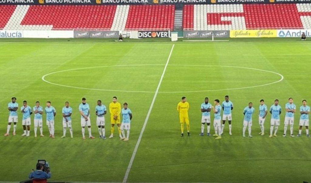 Plantel de Universidad Católica formado en el centro del estadio Rodrigo Paz Delgado con las tribunas vacías, esperando a Emelec
