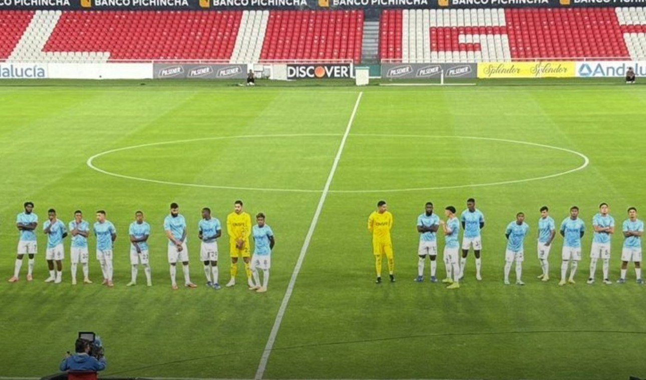 Plantel de Universidad Católica formado en el centro del estadio Rodrigo Paz Delgado con las tribunas vacías, esperando a Emelec