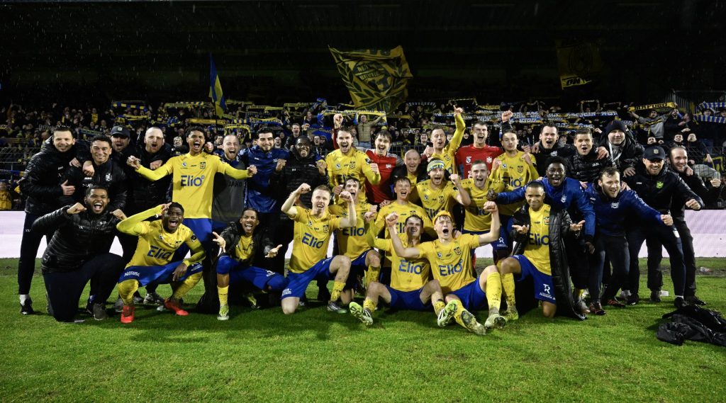 Plantel y cuerpo técnico de SK Beveren festejan el ascenso a la Jupiler Pro League con la hinchada de fondo