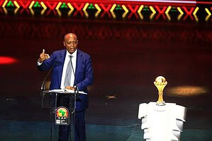 Patrice Motsepe, presidente de la CAF, habla en un podio con el trofeo de la Copa Africana de Naciones a su lado