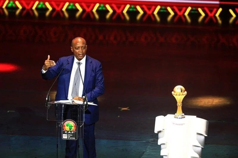 Patrice Motsepe, presidente de la CAF, habla en un podio con el trofeo de la Copa Africana de Naciones a su lado