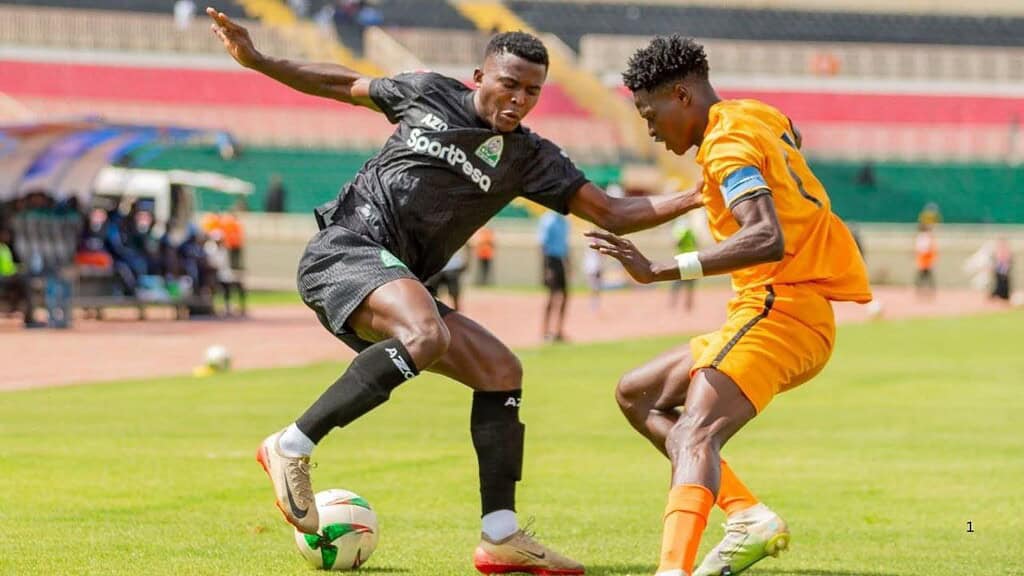 Jugador de Gor Mahia (negro) y jugador de BB Bread FC (naranja) disputan el balón en el Estadio Nyayo, Nairobi