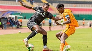 Jugador de Gor Mahia (negro) y jugador de BB Bread FC (naranja) disputan el balón en el Estadio Nyayo, Nairobi