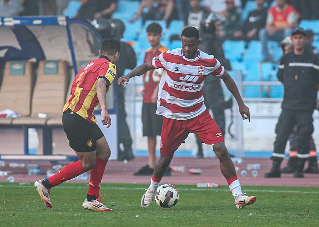 Jugador del Club Africain controla el balón ante un defensor del Espérance de Tunis en el derby de la capital