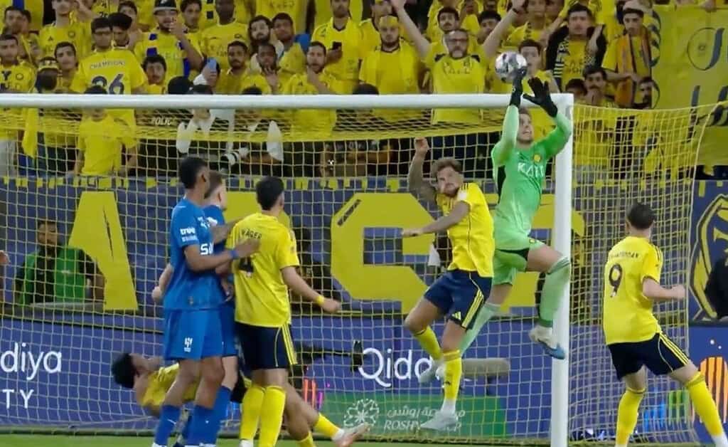 Bento, arquero de Al-Nassr, salta a cortar un centro en el área durante el partido contra Al-Hilal por la Saudi Pro League