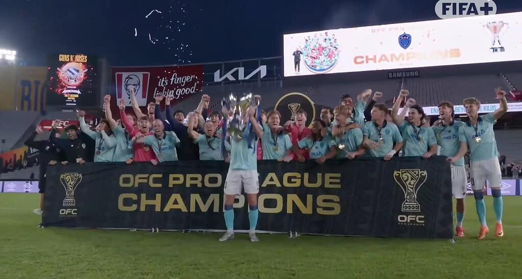 Plantel de Auckland FC celebra con el trofeo y el banner de OFC Pro League Champions en Eden Park