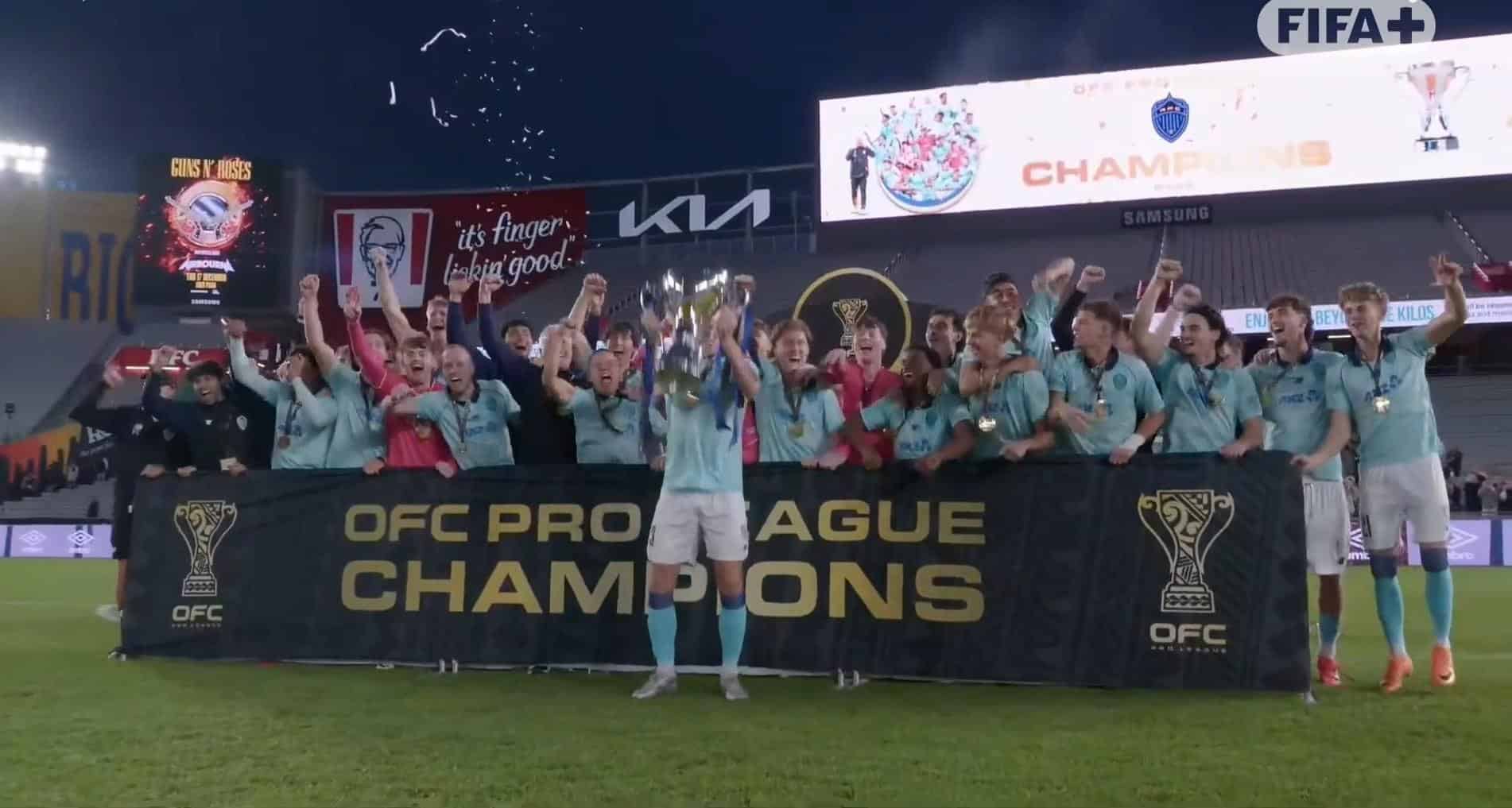 Plantel de Auckland FC celebra con el trofeo y el banner de OFC Pro League Champions en Eden Park