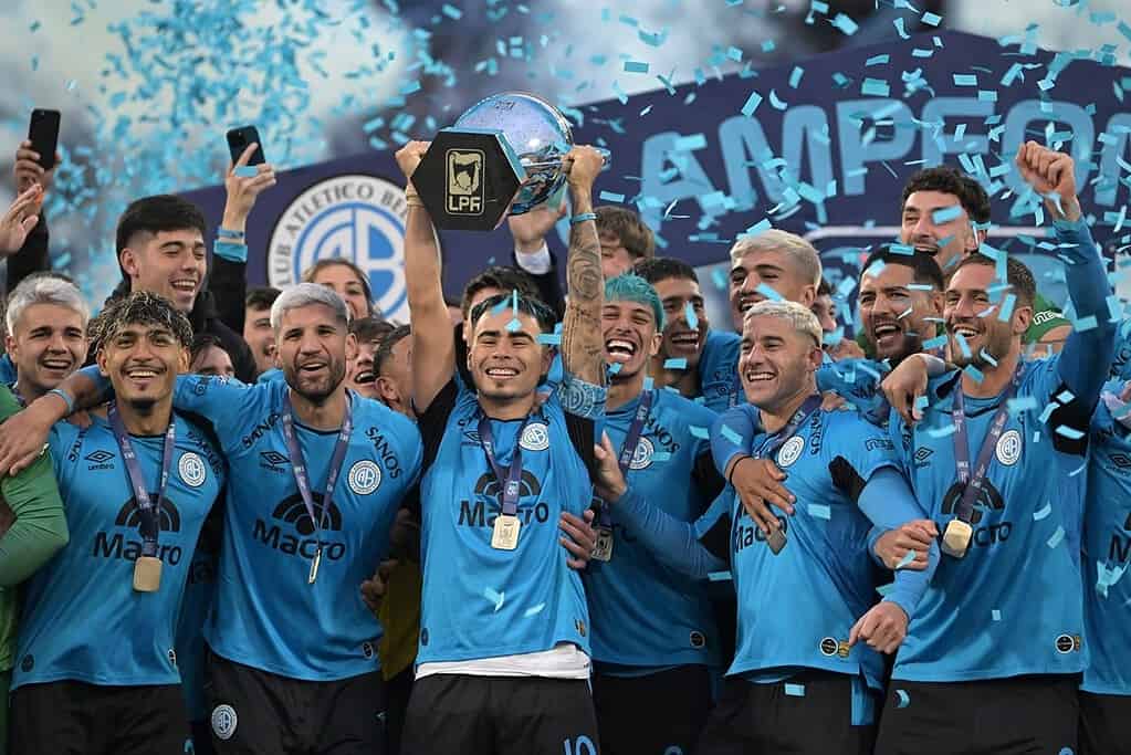 Jugadores de Belgrano levantan el trofeo de la Liga Profesional tras ganar la final del Torneo Apertura 2026 en el estadio Mario Alberto Kempes