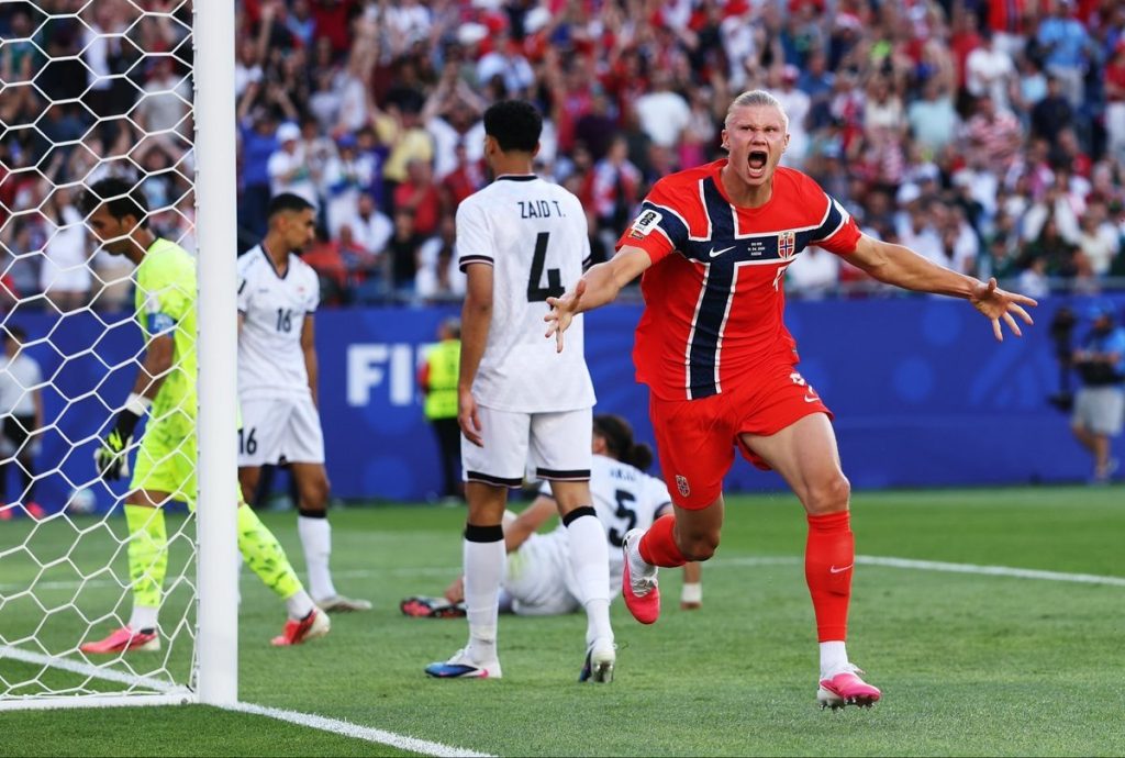 Erling Haaland celebra su gol con la camiseta de Noruega mientras jugadores de Irak quedan tendidos en el Gillette Stadium