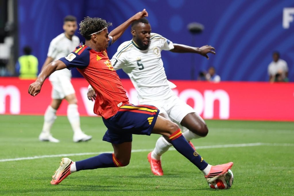 Lamine Yamal, con la camiseta roja de España, encara y remata ante un defensor de Arabia Saudita