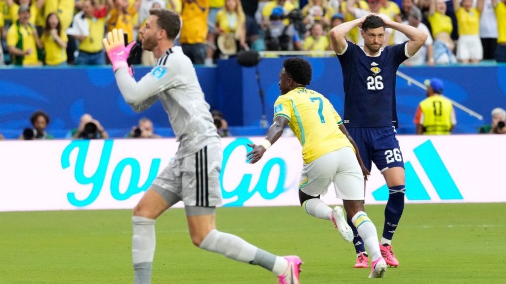 Vinicius Jr festeja su gol con la camiseta numero 7 de Brasil mientras un defensor de Escocia se lamenta con las manos en la cabeza