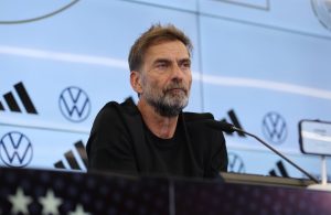 Jürgen Klopp sentado ante los micrófonos en la sala de prensa del DFB-Campus, con el fondo de patrocinadores de la selección alemana
