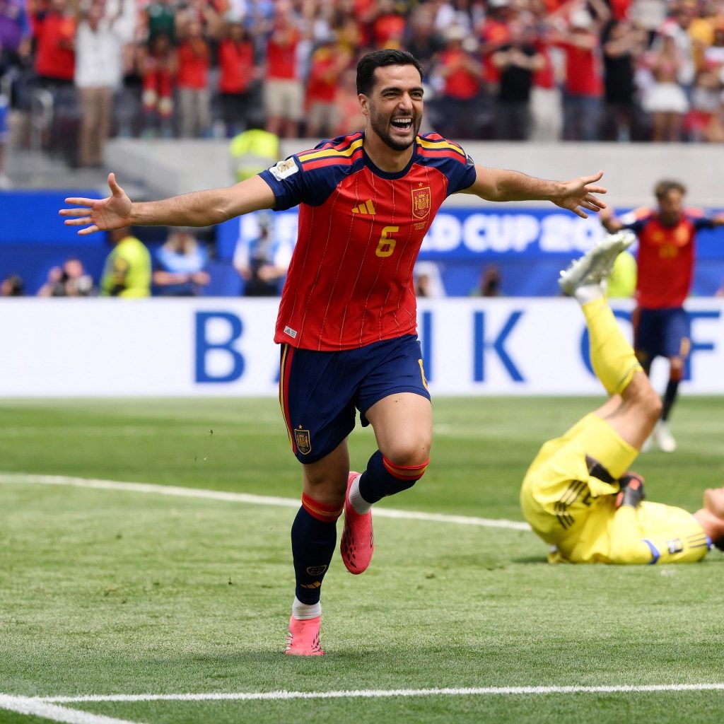 Mikel Merino, con la camiseta número 6 de España, celebra con los brazos abiertos un gol ante un arquero caído