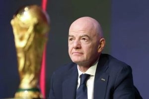 Gianni Infantino, presidente de la FIFA, sentado junto al trofeo de la Copa del Mundo