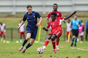 Un jugador de Auckland City, de camiseta azul, disputa la pelota con el número 11 de Central Coast, de rojo, en el cruce entre ambos por la OFC Champions League 2026 en Fiji