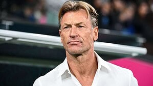 Hervé Renard de camisa blanca, de pie al costado del campo antes de un partido