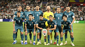 Los once titulares de la selección de Irak posan antes de un partido con la camiseta verde y el escudo nacional en el centro