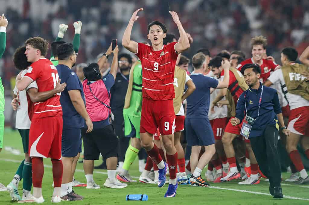 Futbolistas de la selección de Indonesia celebran en el campo de juego, con un jugador de camiseta roja número 9 en primer plano.