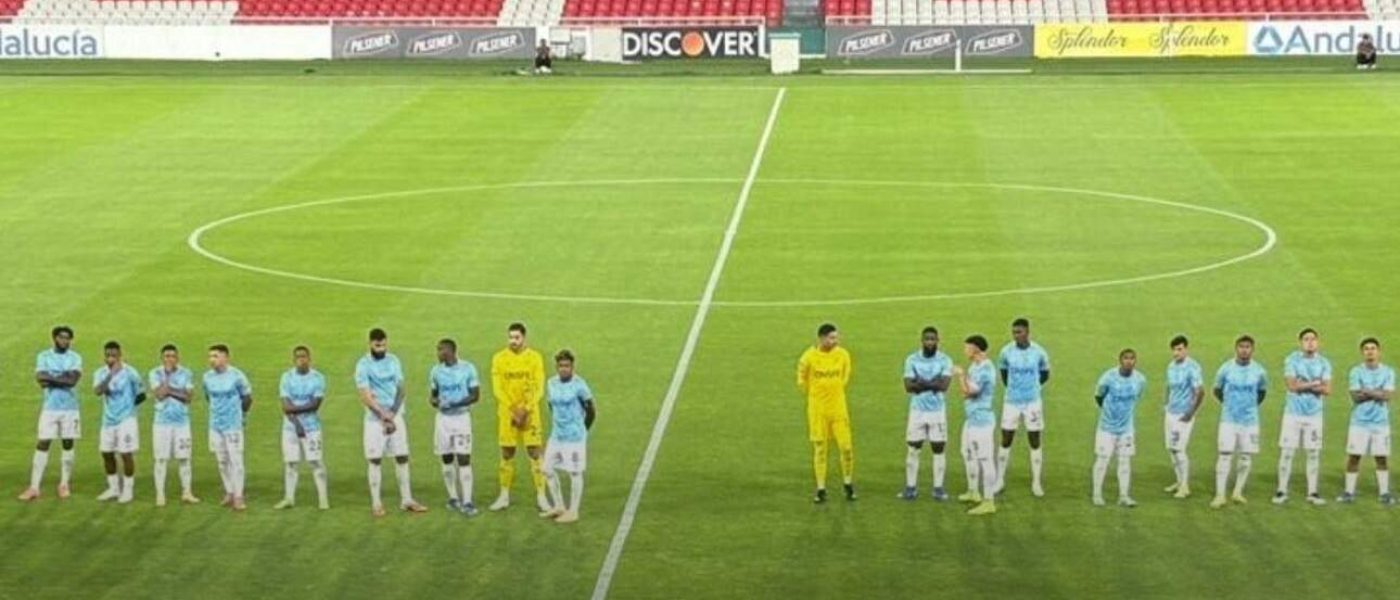 Plantel de Universidad Católica formado en el centro del estadio Rodrigo Paz Delgado con las tribunas vacías, esperando a Emelec