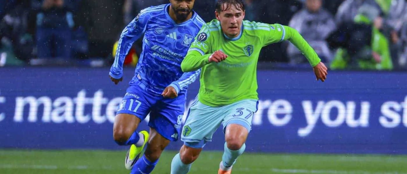 Un jugador de Tigres UANL (#17) y un jugador de Seattle Sounders (#37) disputan la pelota bajo la lluvia en Lumen Field durante la vuelta de cuartos de la Concacaf Champions Cup 2026.