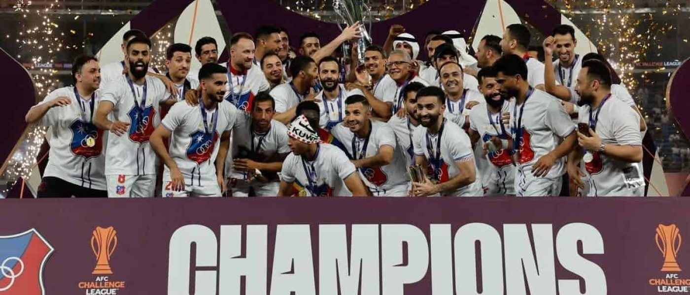 Plantel de Al Kuwait SC celebra con el trofeo de la AFC Challenge League 2026 en el podio de campeones