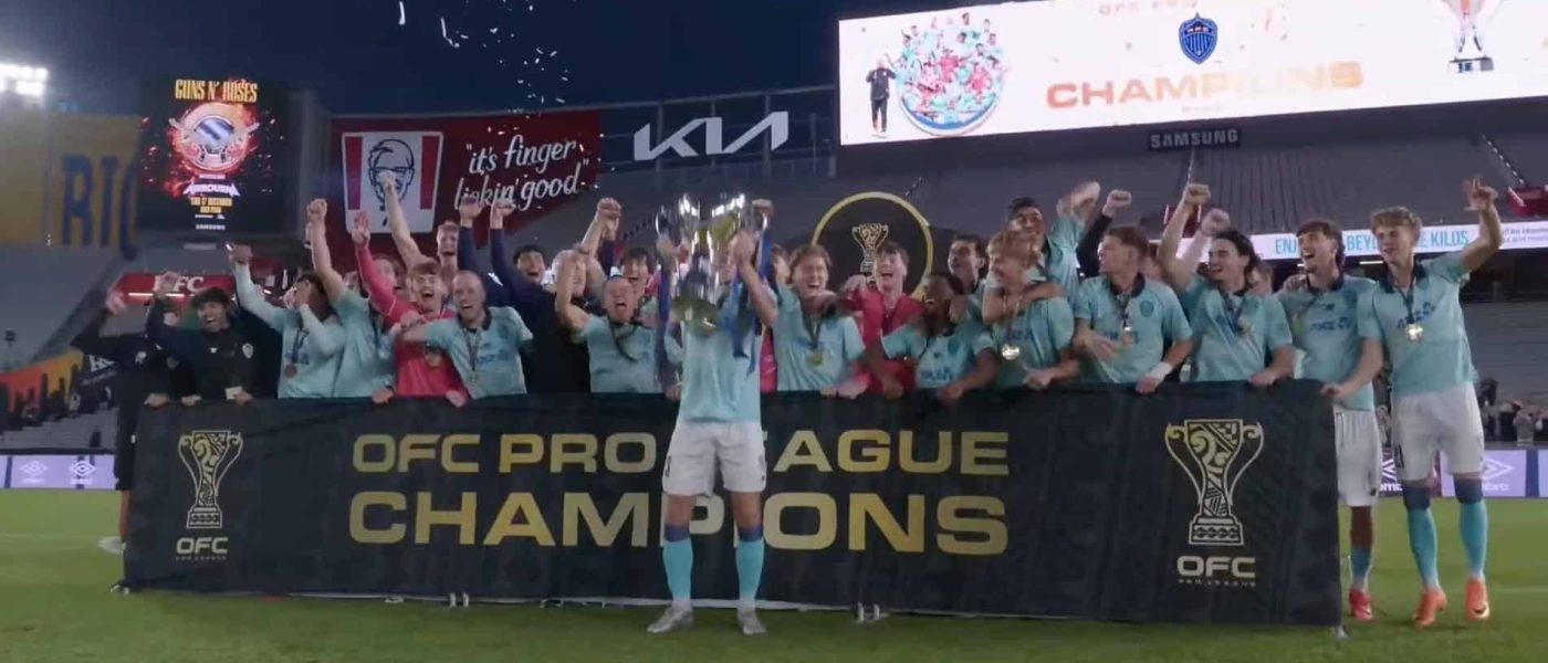 Plantel de Auckland FC celebra con el trofeo y el banner de OFC Pro League Champions en Eden Park