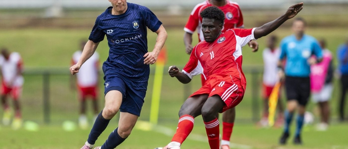 Un jugador de Auckland City, de camiseta azul, disputa la pelota con el número 11 de Central Coast, de rojo, en el cruce entre ambos por la OFC Champions League 2026 en Fiji