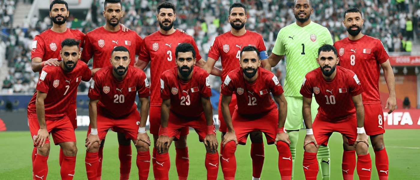 Jugadores de la selección de Bahréin posan con la camiseta roja antes de un partido en un estadio lleno