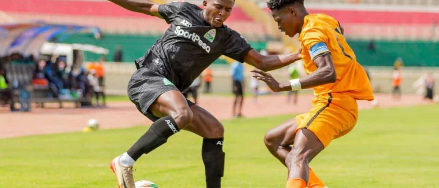 Jugador de Gor Mahia (negro) y jugador de BB Bread FC (naranja) disputan el balón en el Estadio Nyayo, Nairobi