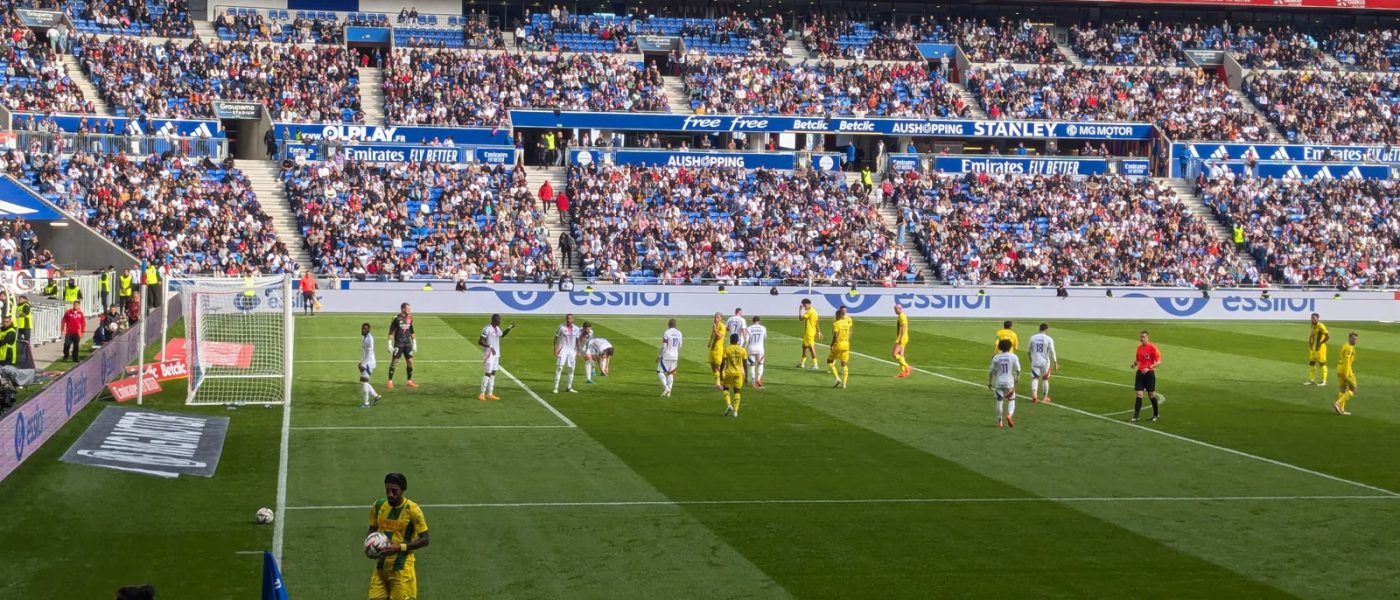Vista del Groupama Stadium de Lyon durante un partido, con el equipo local ejecutando un córner ante una tribuna llena