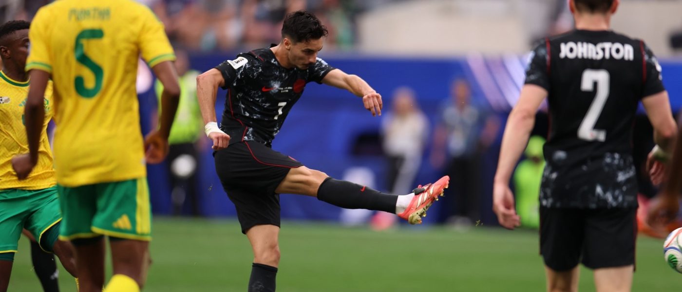 Stephen Eustáquio remata de derecha para marcar el gol de Canadá ante Sudáfrica, con el defensor Johnston de fondo