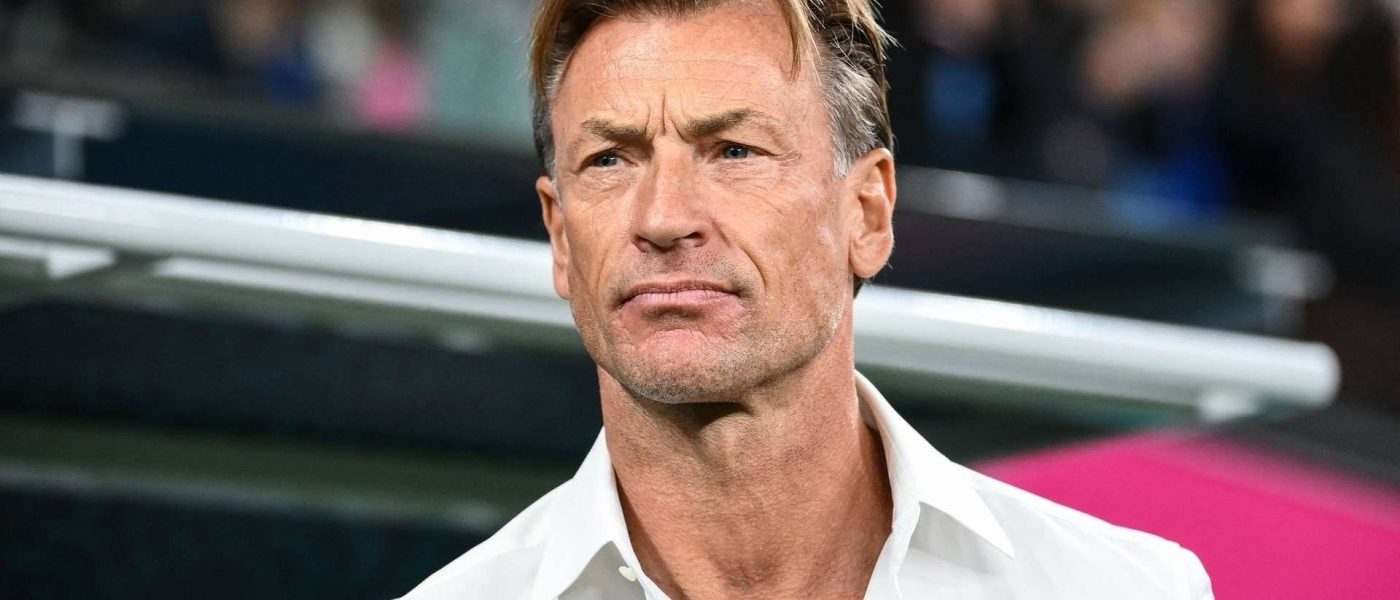 Hervé Renard de camisa blanca, de pie al costado del campo antes de un partido