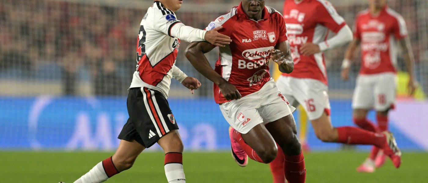 Un jugador de River Plate conduce la pelota presionado por un futbolista de Independiente Santa Fe en el Estadio Monumental